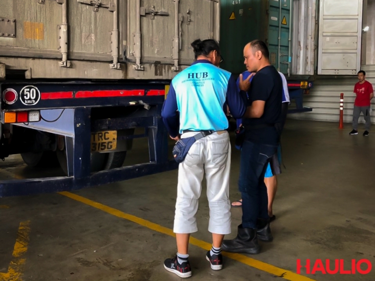 Uncle Foong talking to other truck drivers and the depot container inspector